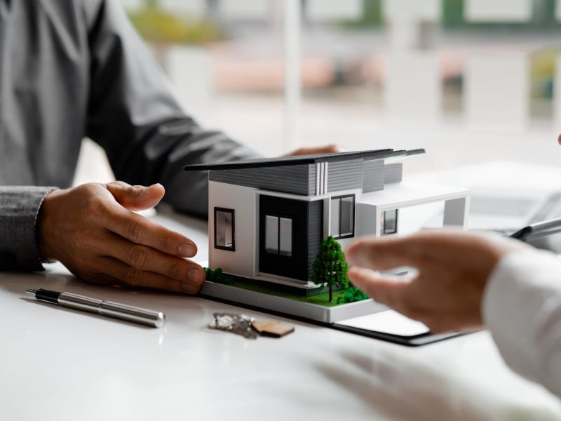 Real estate agents explain models of housing estates in projects Real estate agents explain models of housing estates in projects to elaborate to clients, explaining and presenting information about homes and purchasing loans. Real estate trading concept.
